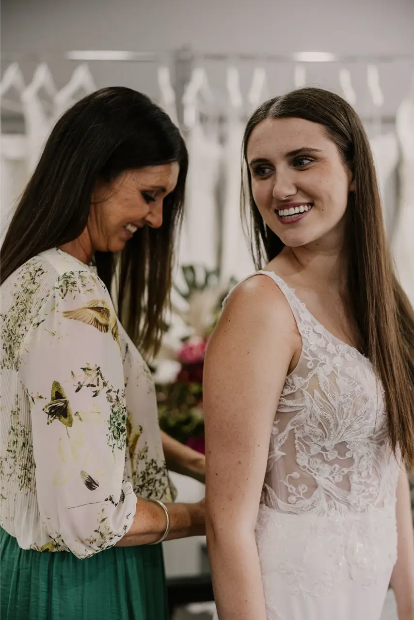 RSVP Bridal store owner fitting a lace bodice wedding dress on a young bride