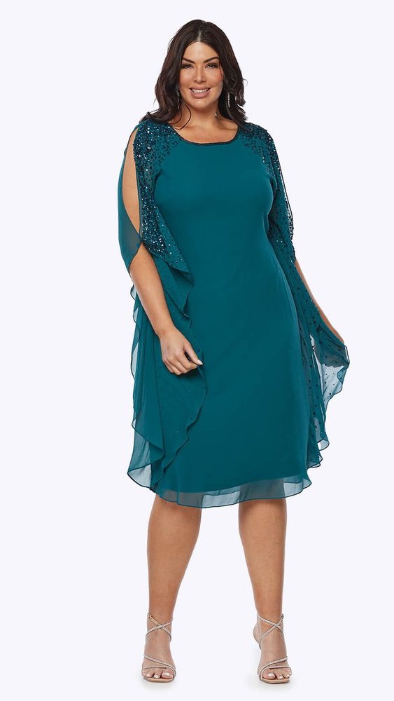Layla Jones LJ0485 knee length, georgette dress , with a beaded neckline cascading down cold shoulder waterfall sleeves. Plus size model wearing emerald.