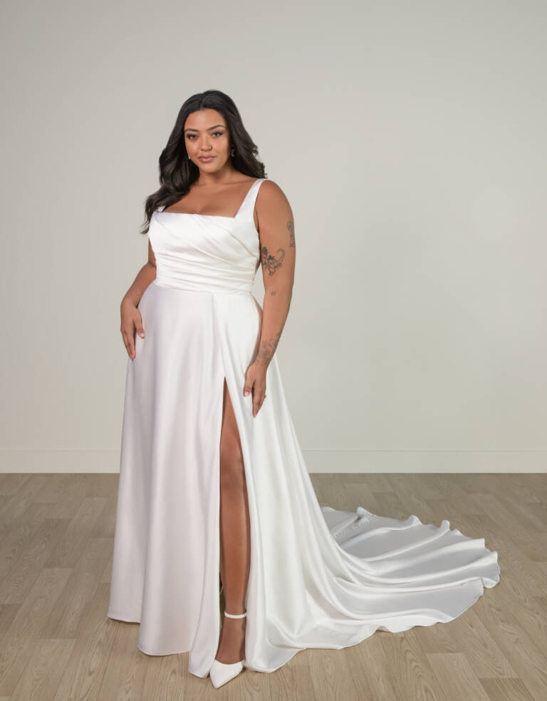 Bride wearing Stella York Style SY8110 in ivory — a satin A-line wedding dress with a ruched bodice, square neckline, leg slit, and scoop back with button detail.