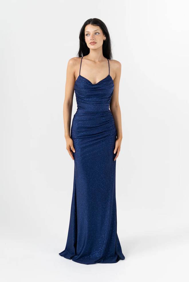 Model wearing Vega PO25108 formal dress by Tania Olsen Designs. Fitted sparkle knit with draped shash across bodice, spaghetti straps and v-neckline in Navy