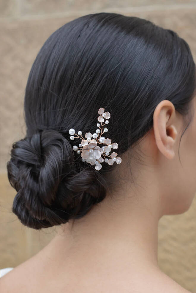 Woman with brunette hear wearing Iris Hairpin WP123 in Rose Gold. Pearls and sprigs of pearls surround a fine hand painted flower