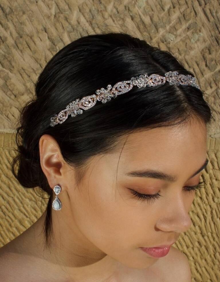 Close-up of a bride wearing the Windsor Bridal Bonnie Crystal Headband WH690—rose-gold tone crystals on a slim band, styled with a sleek low bun.