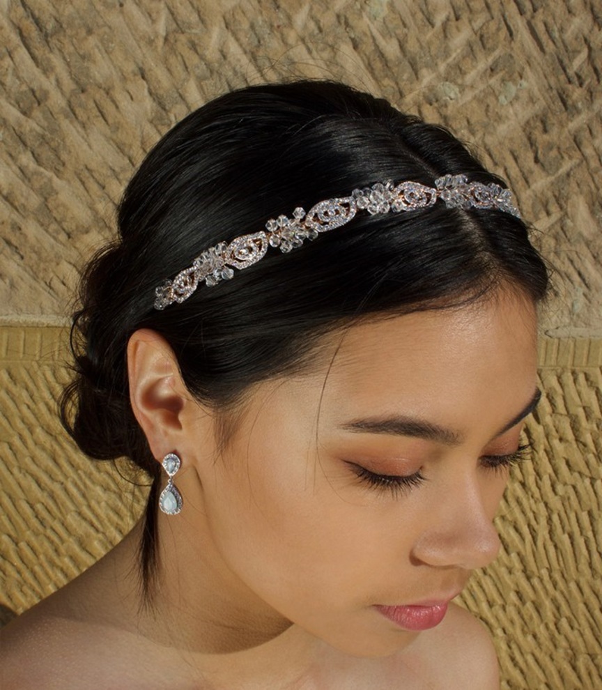 Close-up of a bride wearing the Windsor Bridal Bonnie Crystal Headband WH690โrose-gold tone crystals on a slim band, styled with a sleek low bun.