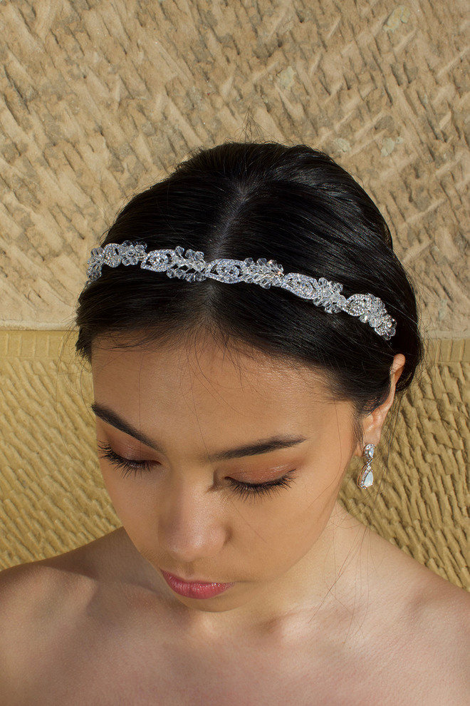 Close-up of a bride wearing the Windsor Bridal Bonnie Crystal Headband WH690โsilver crystals on a slim band, styled with a sleek low bun.