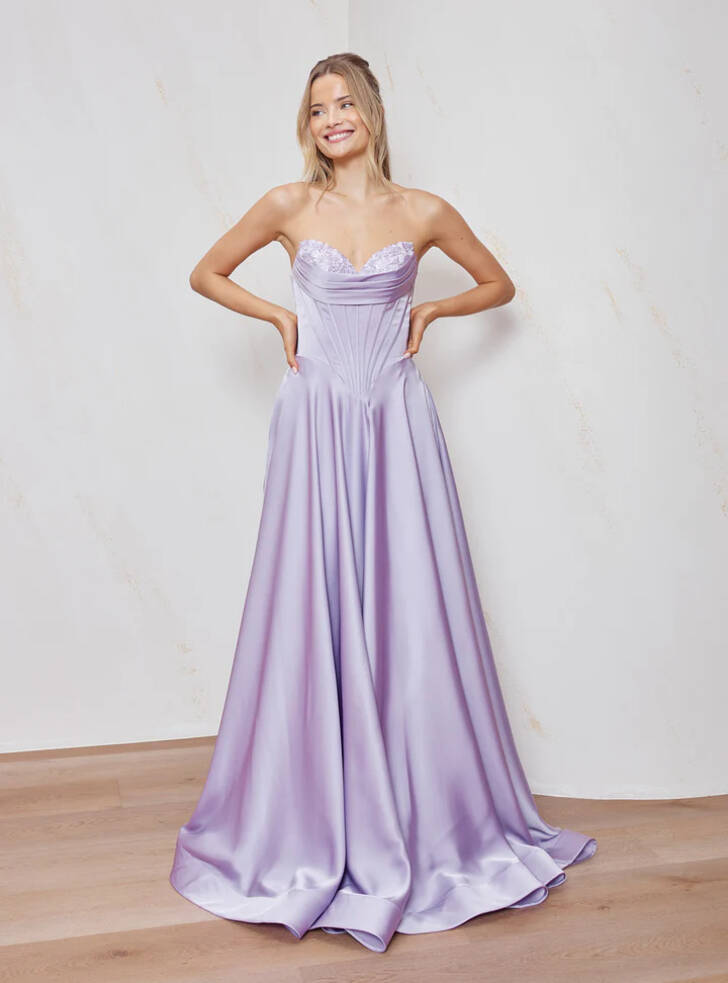Model wearing lilac satin Cadence formal dress by Tania Olsen, strapless sweetheart corset bodice with boning and deep basque waist, full A-line skirt.