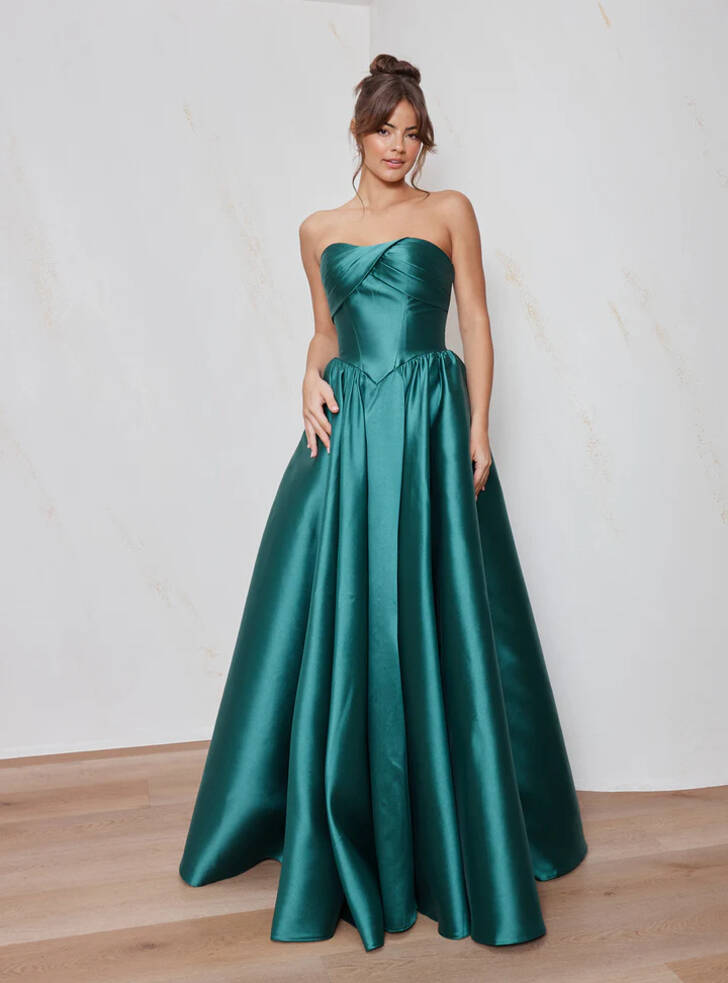 Model wearing emerald Catira formal dress by Tania Olsen, strapless mikado A-line gown with basque waist and full skirt.