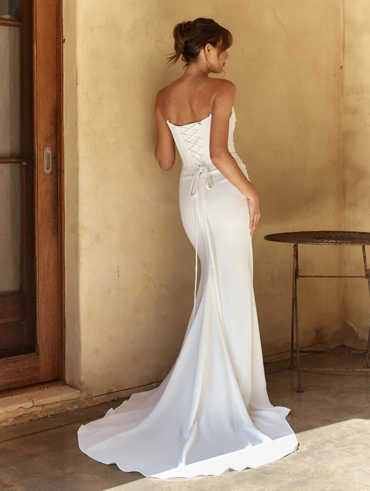 Back view of the April wedding dress by Tania Olsen Bridal featuring a corset lace-up back with modesty panel, structured basque waistline, and a sweeping cathedral-length train.