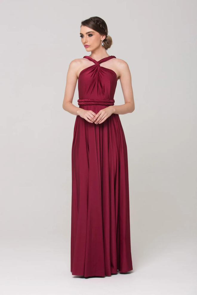 Model wearing the Tania Olsen PO31 wrap dress in merlot with a twisted high neckline, wrap waistband, and soft floor-length jersey skirt.