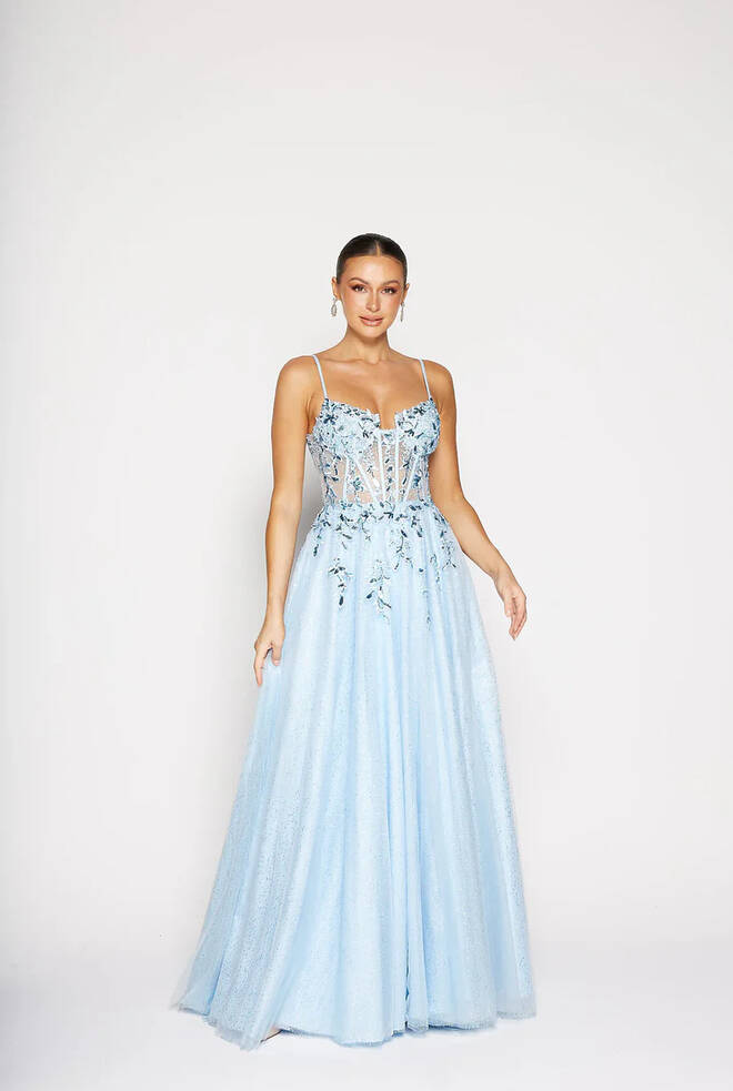 Front view of the Niara PO2488 formal dress by Tania Olsen Designs in pale blue glitter tulle with lace appliqué bodice, thin straps, corset detailing, and full A-line skirt.