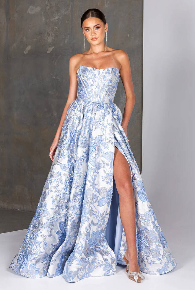 Dakota PO26142 strapless blue metallic brocade formal gown with structured bodice, thigh-high split and full skirt.