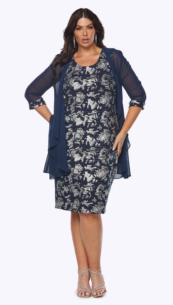 Model wearing the Layla Jones LJ0563 midnight navy stretch jersey foil print dress with matching chiffon jacket, featuring a scoop neckline and knee-length silhouette.