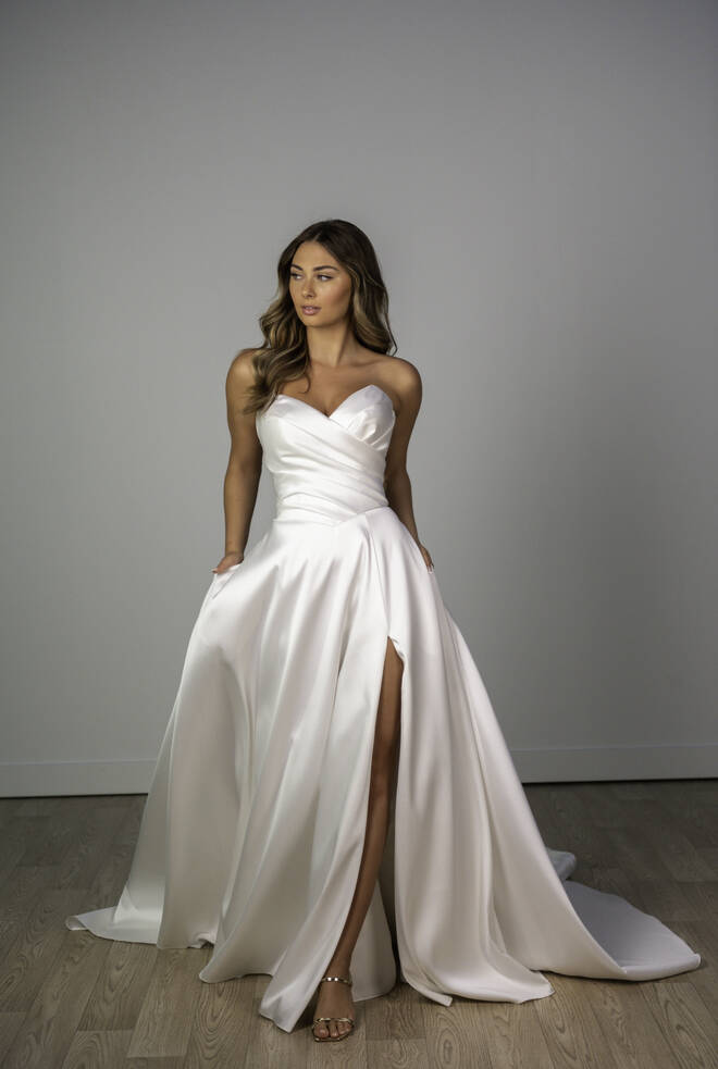 Stella York SY8191 minimalist wedding dress with sweetheart neckline, draped bodice, A-line skirt and high leg slit.